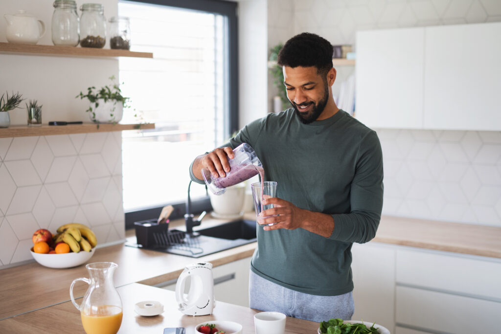 man pouring a smoothie staying hydrated