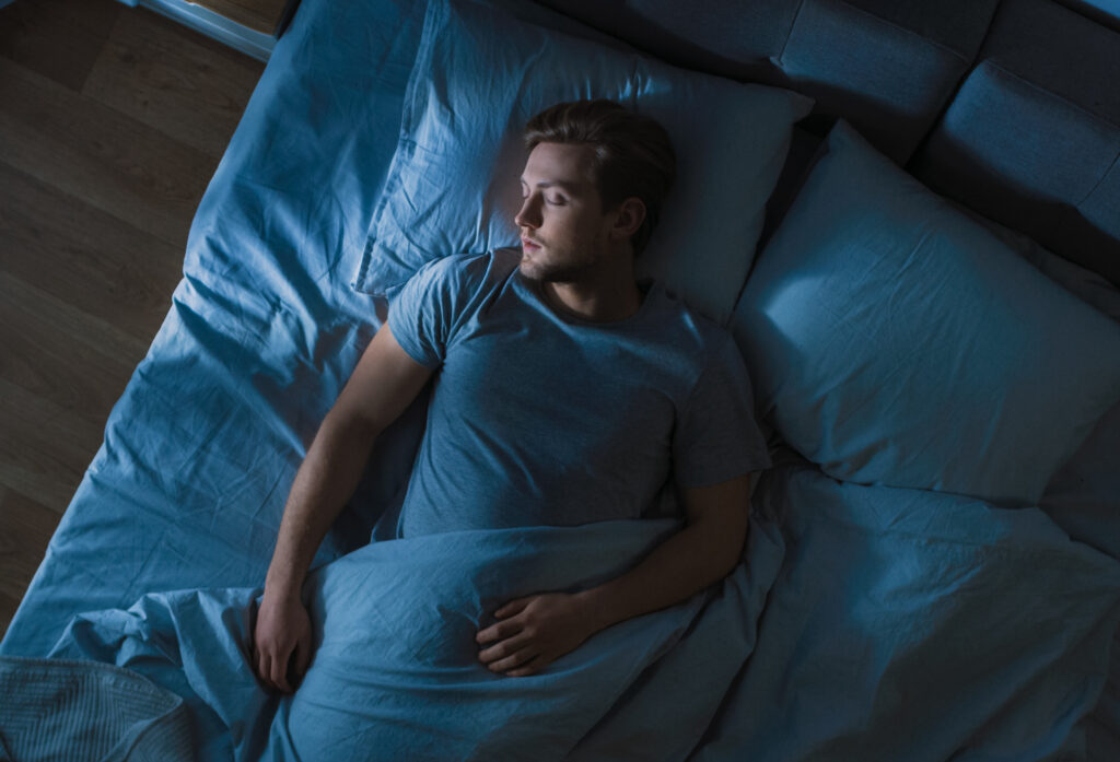 man having restful sleep in dark room